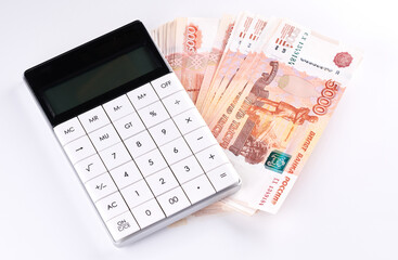 Russian rubles five thousandth banknotes, calculator and stack of money on white background