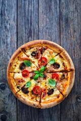 Circle pizza with boiled ham and  mushrooms on wooden table
