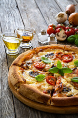 Circle pizza with boiled ham and  mushrooms on wooden table
