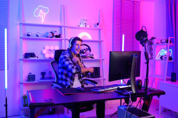 Young Caucasian man Pro Gamer have live streaming  and chatting  with his  fans at home