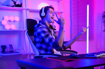 Young Caucasian man Pro Gamer have live streaming  and chatting  with his  fans at home