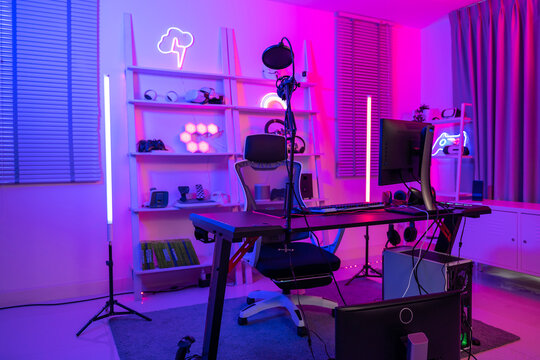 Background of gaming room with neon light , live streaming equipment .