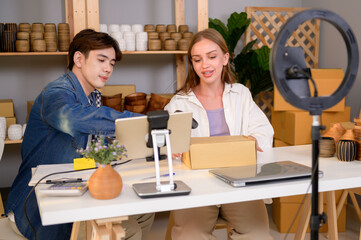 A young couple entrepreneur live streaming to sale craft products  to customers in them shop , Technology online business concept.