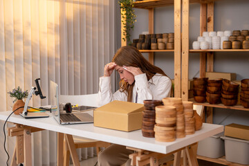 A young caucasian woman entrepreneur feeling disappointed with his business growth in her shop