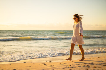 Fototapeta na wymiar Beach holiday - beautiful woman walking on sunny, tropical beach 