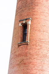 Close up of Currituck Beach Lighthouse, Outer Banks, Corolla, North Carolina showing lone window amid red  brick tower