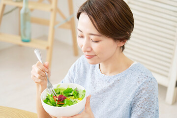 家でサラダを食べる女性