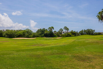 Fototapeta na wymiar Beautiful view of green grass golf field on background blue sky on Aruba island. 