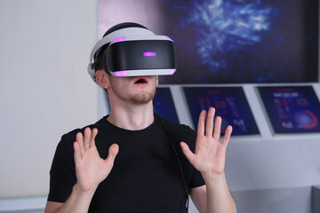 Portrait of happy young handsome man, guy using, wearing a modern device virtual reality headset mask or 3D, AR, VR glasses, playing the game. People and technology metaverse concept 