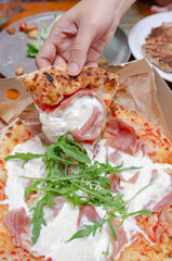 A baker making bread in the kitchenPizza with parma ham Italian style in a paper box