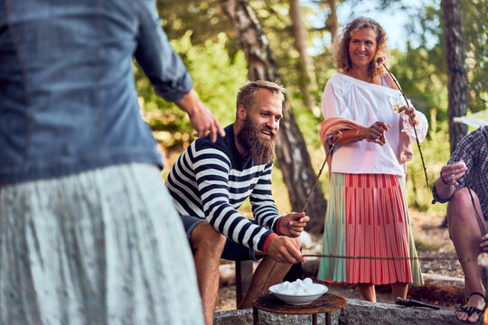 Friends toasting marshmallows over a fire
