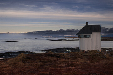 old lighthouse at the coast with mountain view