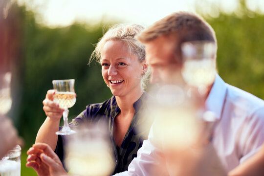 Smiling woman making a toast outside