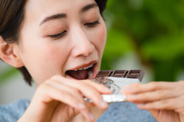 チョコレートを食べる若い女性　飲食イメージ