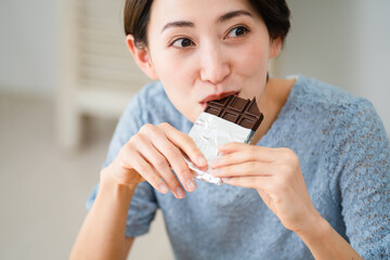 チョコレートを食べる若い女性　飲食イメージ