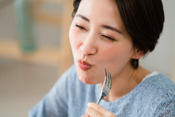 ブロッコリーを食べる若い女性　飲食イメージ