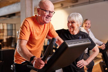 Smiling seniors exercising together in a gym