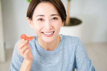 トマトを食べる若い女性　飲食イメージ