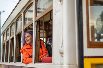 Girl Looking Out The Window In The Tram.
Woman In Orange Shirt Looking Out The Window On The Train...