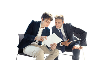 Mature businessman using a digital tablet to discuss information with a younger colleague in a...