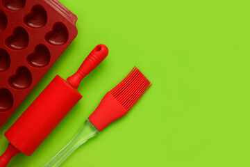 culinary background, culinary spatula, brush, baking dish on a bright green background with copy space