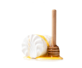 Honey is poured on marshmallows with a dipper on a white background