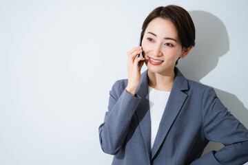 スマートフォンで通話をする若い女性　ビジネスイメージ