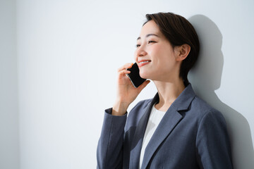 スマートフォンで通話をする若い女性　ビジネスイメージ