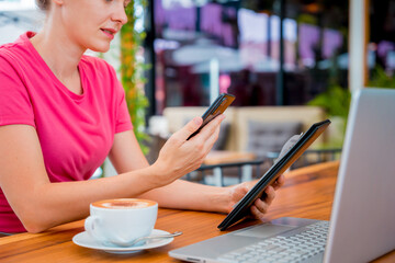 Woman using contactless payment by mobile phone with QR code at cafe