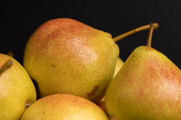 A yellow ripe pear with a red side on the table