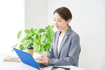 オフィスでノートパソコンを使うビジネスウーマン