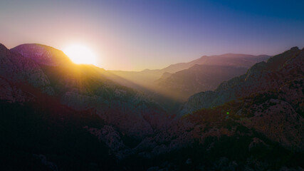 red sun rising through the mountains