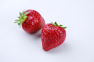 Reife rote Erdbeeren aus biologischem Anbau angeboten als close-up auf einem weißen Board mit...