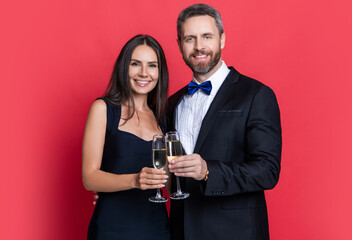 image of couple cheering and celebrate with champagne. couple cheering and celebrate isolated on red