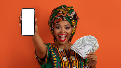 Joyful black lady celebrating success, showing smartphone and dollar cash
