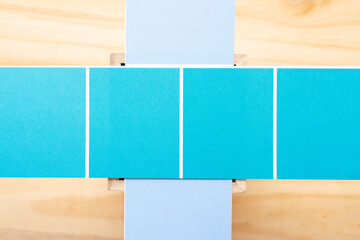 paper stripes with square balanced on a wooden box all on a wooden surface