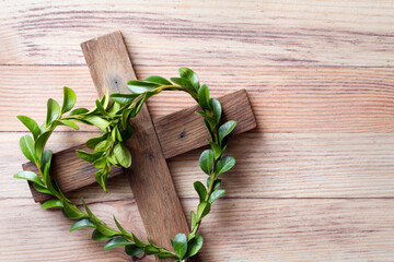 Wooden cross with sprigs of boxwood in heart-shaped, easter symbol of life, religious concept