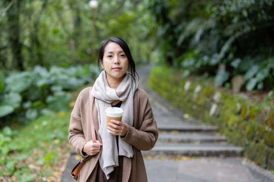Woman hold with a cup of coffee over hiking background - Powered by Adobe