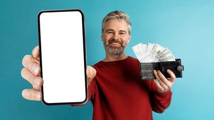 Happy middle aged man showing cell phone and cash