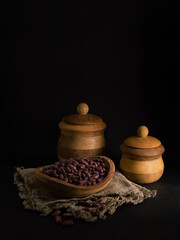 Red beans in a wooden plate on a black background.
