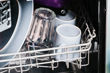 Inside dishwasher view. Washing dishes background. Full shelf with load of glassware. Home utensils cleaning. Kitchen background. Dish wash background. Saving water method. Eco housework.