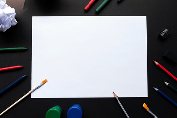 Top view of empty white sheet of paper with painting tools or drawing tools.
