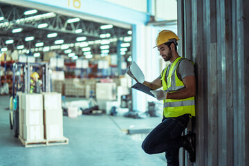 Caucasian male worker wearing Hard Hat with clipboard Checks Stock and Inventory in the Retail Warehouse.