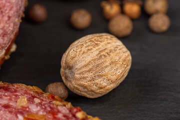 A whole nutmeg on a black stone serving board