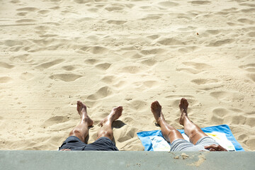 Unrecognizable elderly people sunbathing on the beach