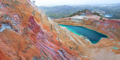 Abandoned copper mines of Cyprus. Colorful gossan (iron cap) of Alestos mine with open pit filled...