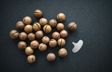 Macadamia nuts on a black background.Round nuts with a key.