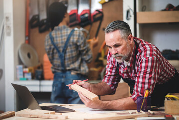 Professional senior cauasian man working woodworking handmade with tools in wood workshop, Timber factory industry.