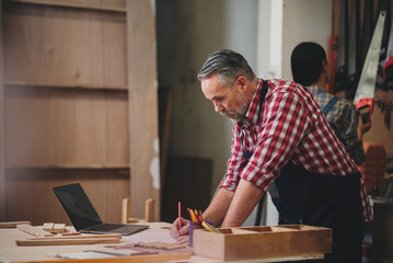 Professional senior cauasian man working woodworking handmade with tools in wood workshop, Timber factory industry.