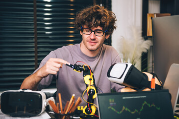 Caucasian young man studying by self in robotic system and Virtual Reality vr glasses controller ,...